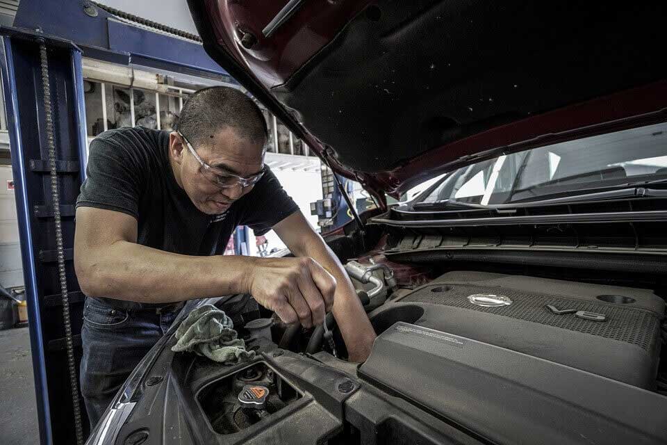 mechanic replacing trunk lift struts